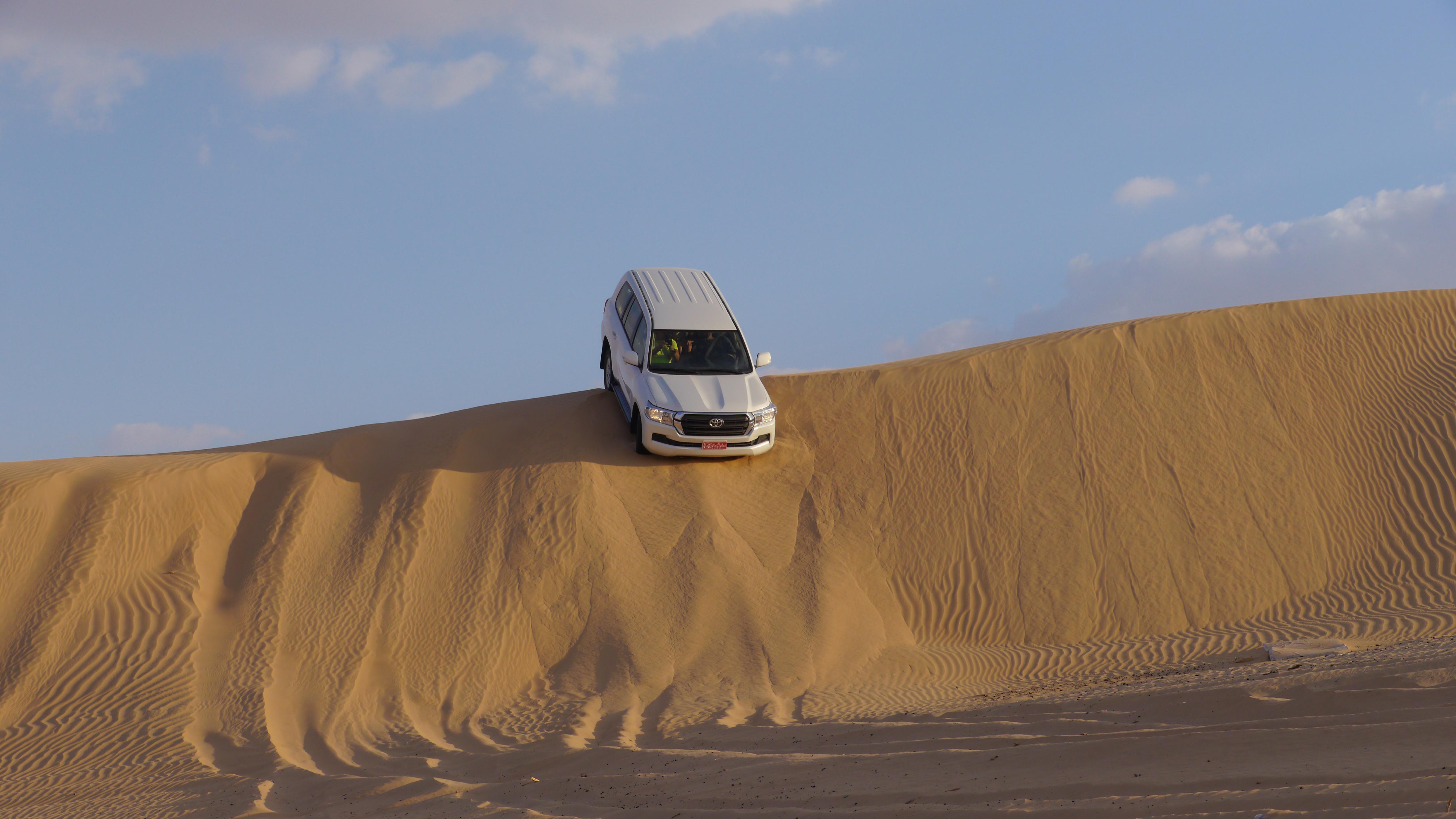 Dune riding in Landcruiser cars, trip to the Empty Quarter from Salalah, Oman. Desert sunset trip and overnight in the desert.