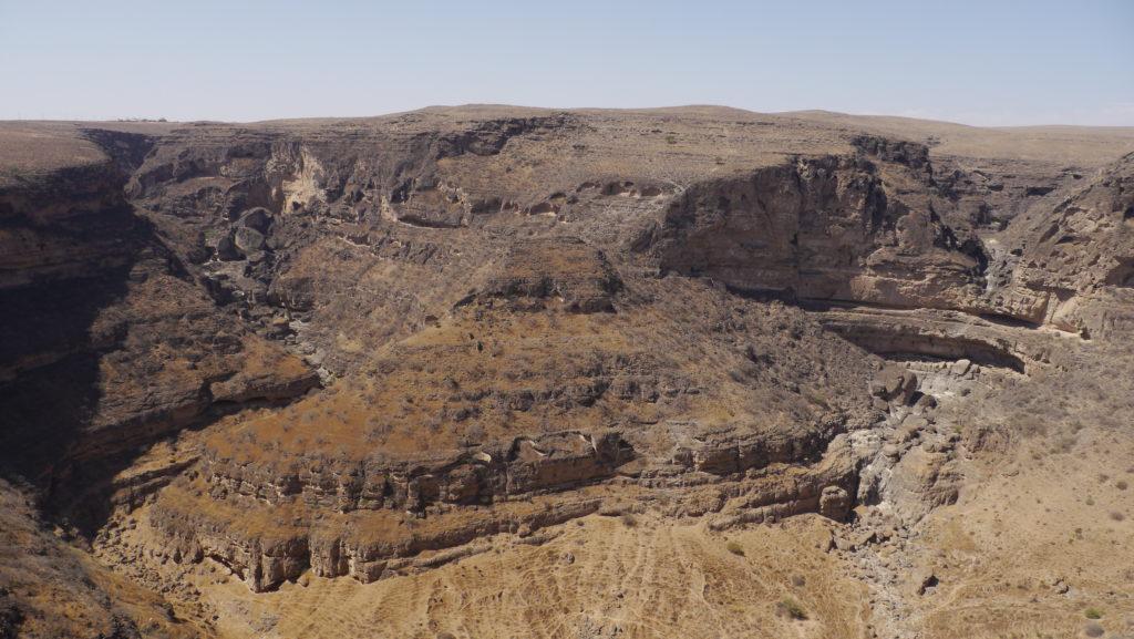 Imposant canyon Tayiq in the Jebel Samhan mountain range. Mountain Safari trip from Salalah.